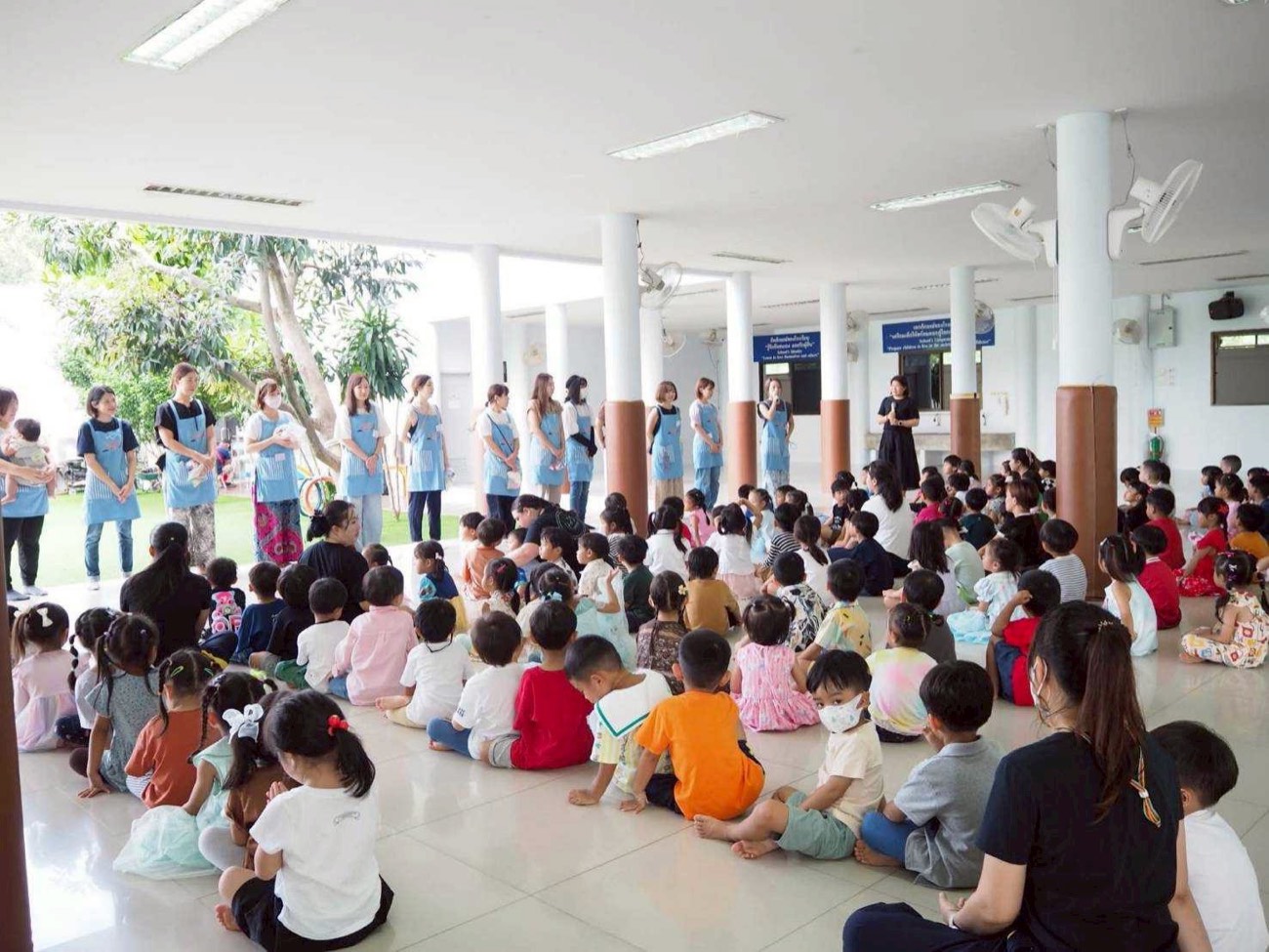 ครูและผู้ปกครองอาสาร่วมกิจกรรมกับเด็ก ๆ ในหอประชุมของโรงเรียน