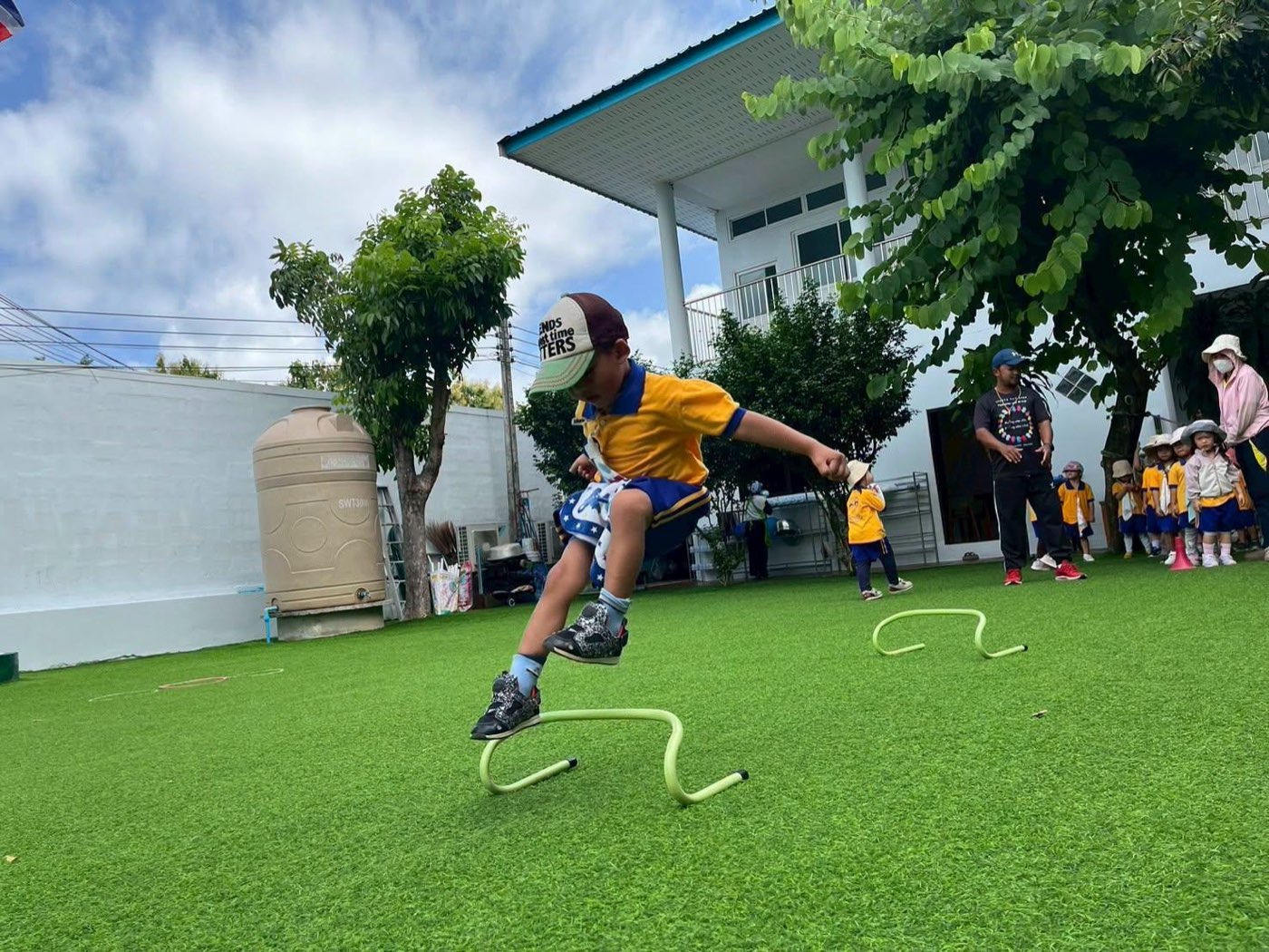 สนามหญ้ากลางแจ้งของโรงเรียนในวันแดดใส บรรยากาศที่รอต้อนรับครอบครัวมาเยี่ยมชม