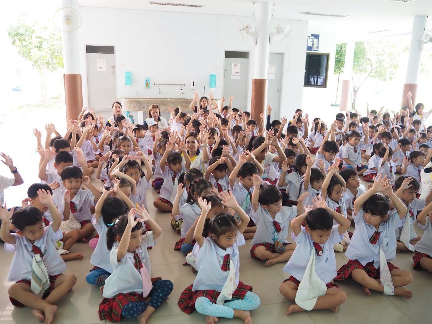 เด็ก ๆ ทั้งโรงเรียนยกมือร่วมกิจกรรมรวมอย่างสนุกสนานในหอประชุม